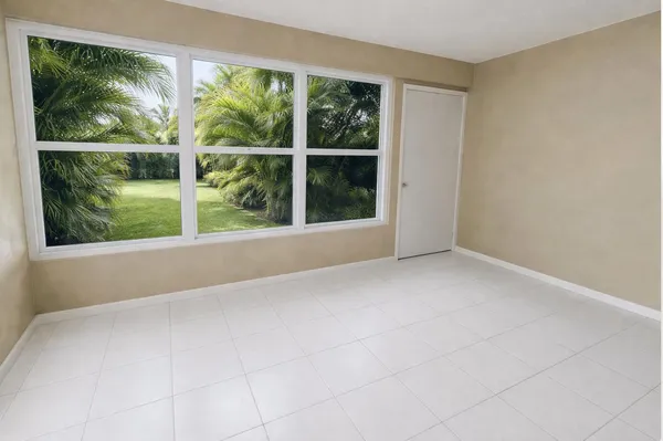 a view of an empty room with a window and a yard