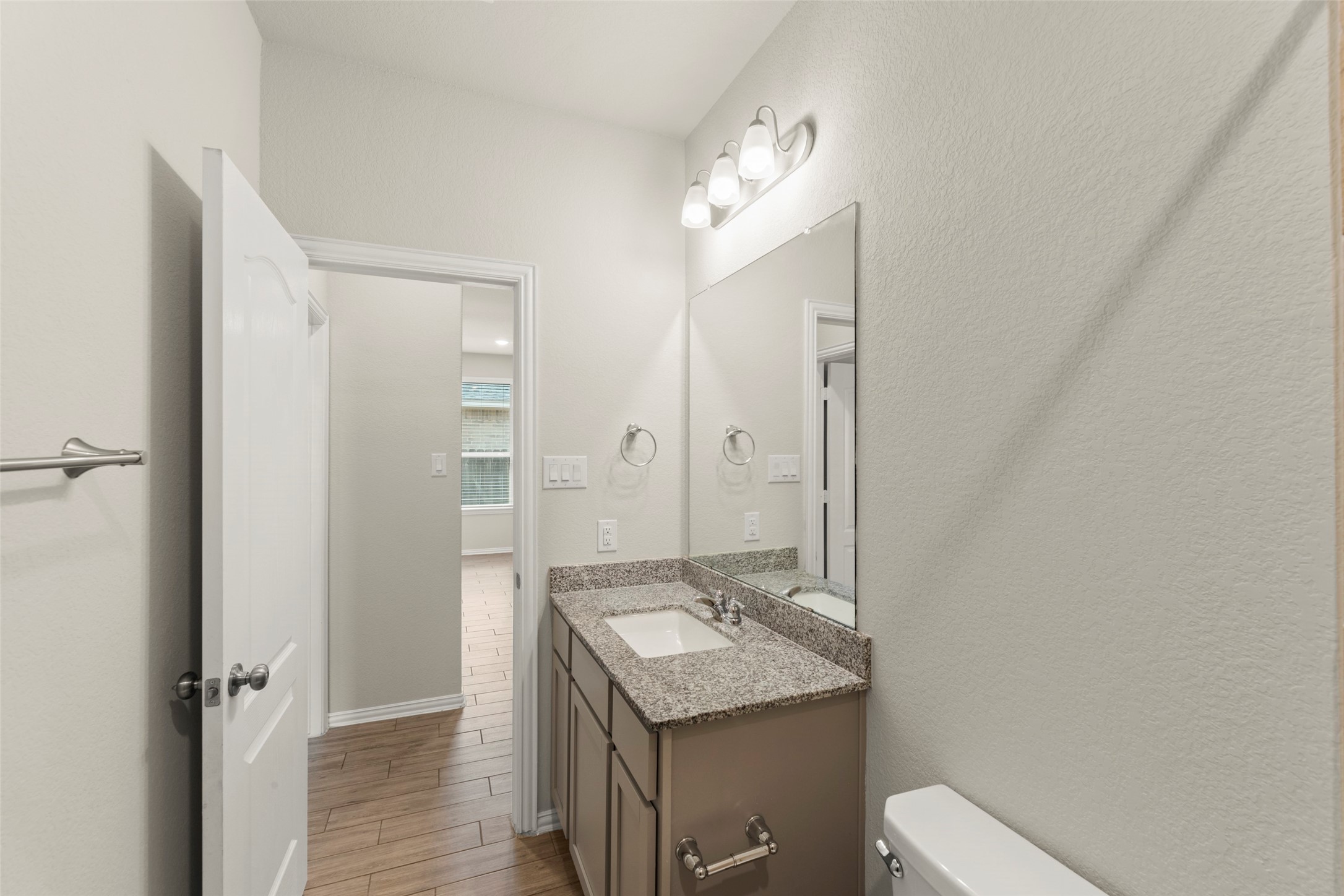 31322 Conover Drive Fulshear, TX 77441 - Photo 22 of 38 a bathroom with a granite countertop sink a toilet a mirror and shower