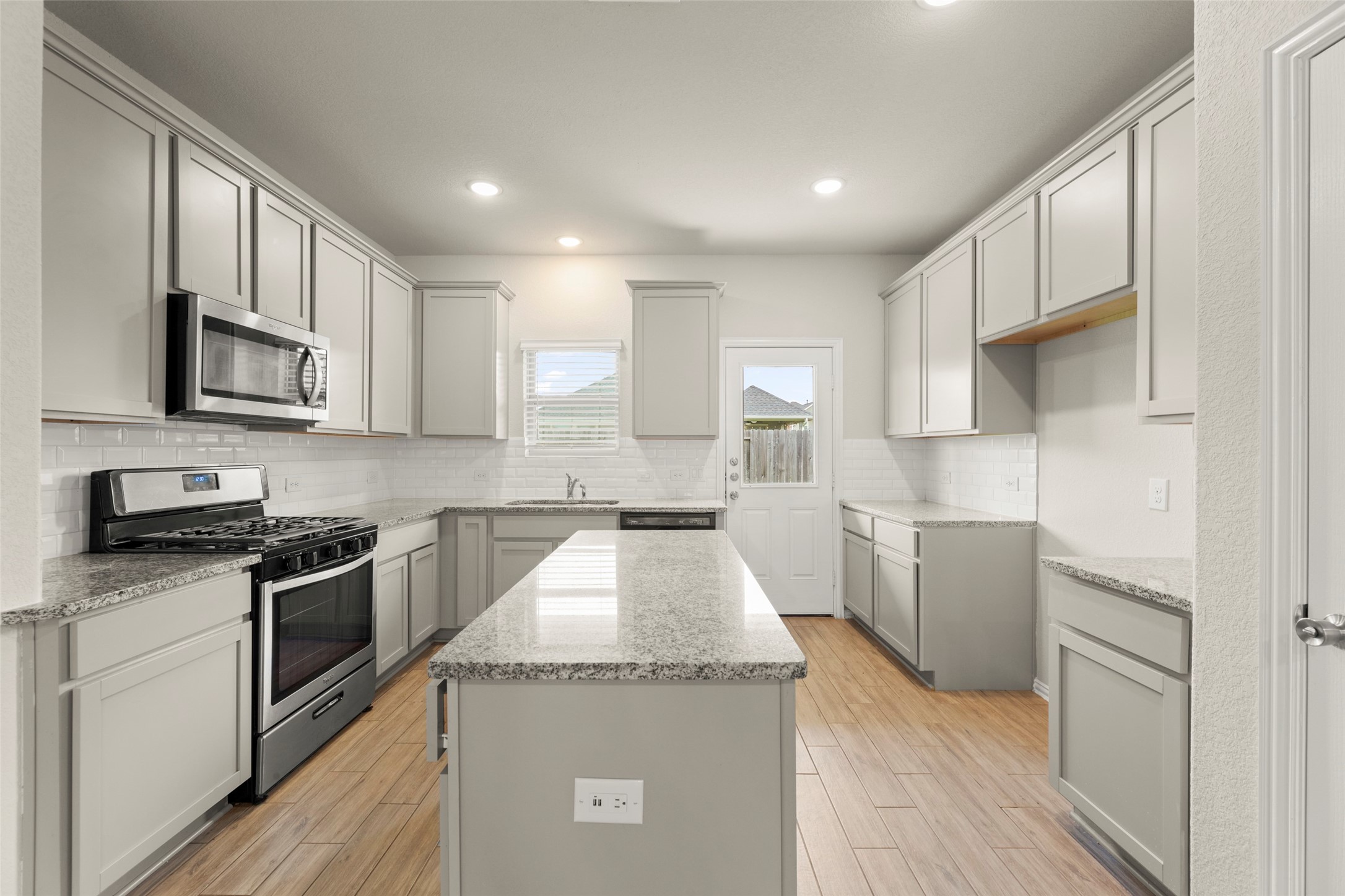 31322 Conover Drive Fulshear, TX 77441 - Photo 4 of 38 a kitchen with granite countertop a sink and steel appliances