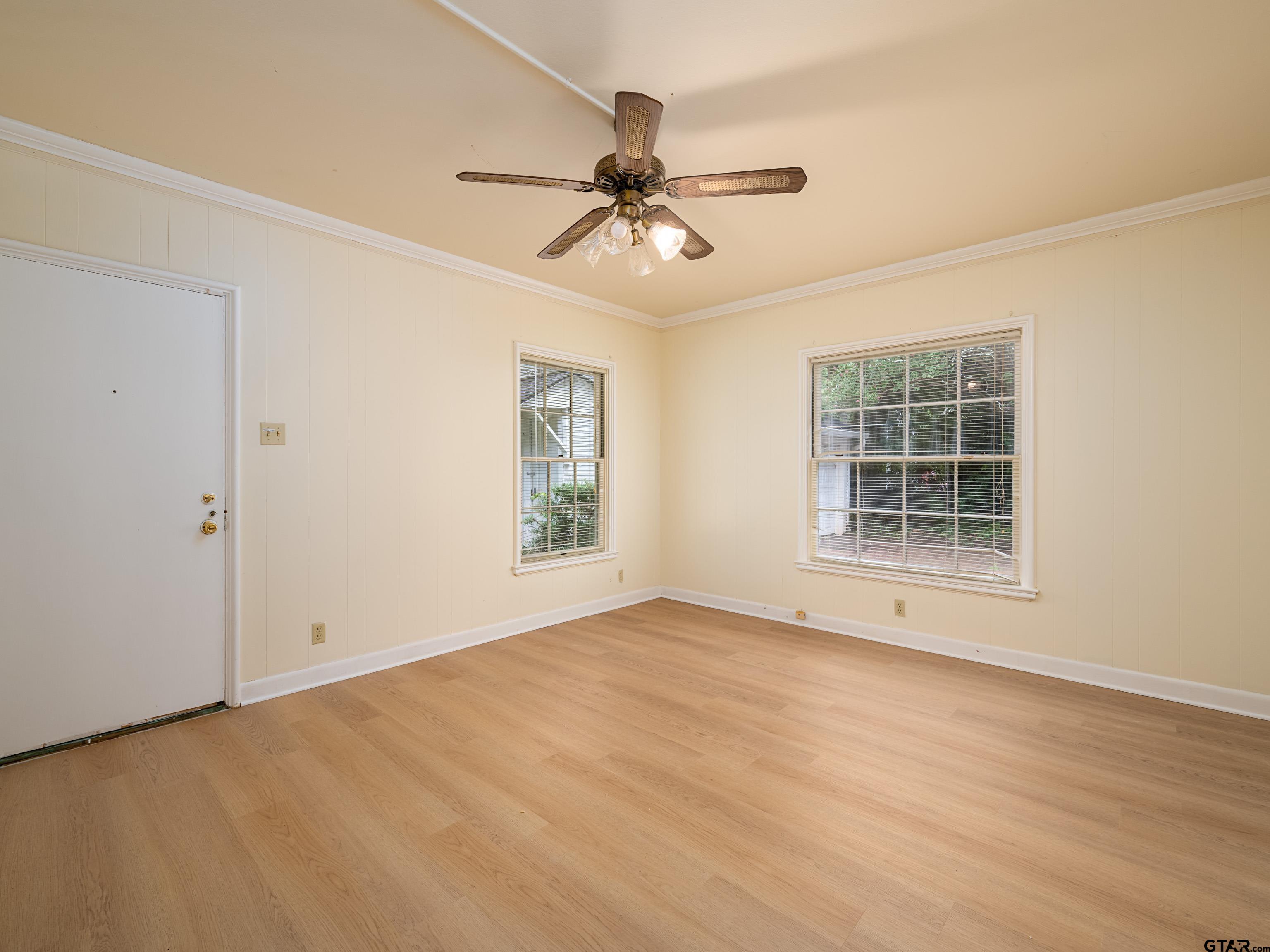 201 West Rusk Street Tyler, TX 75701 - Photo 17 of 30 an empty room with wooden floor chandelier fan and windows