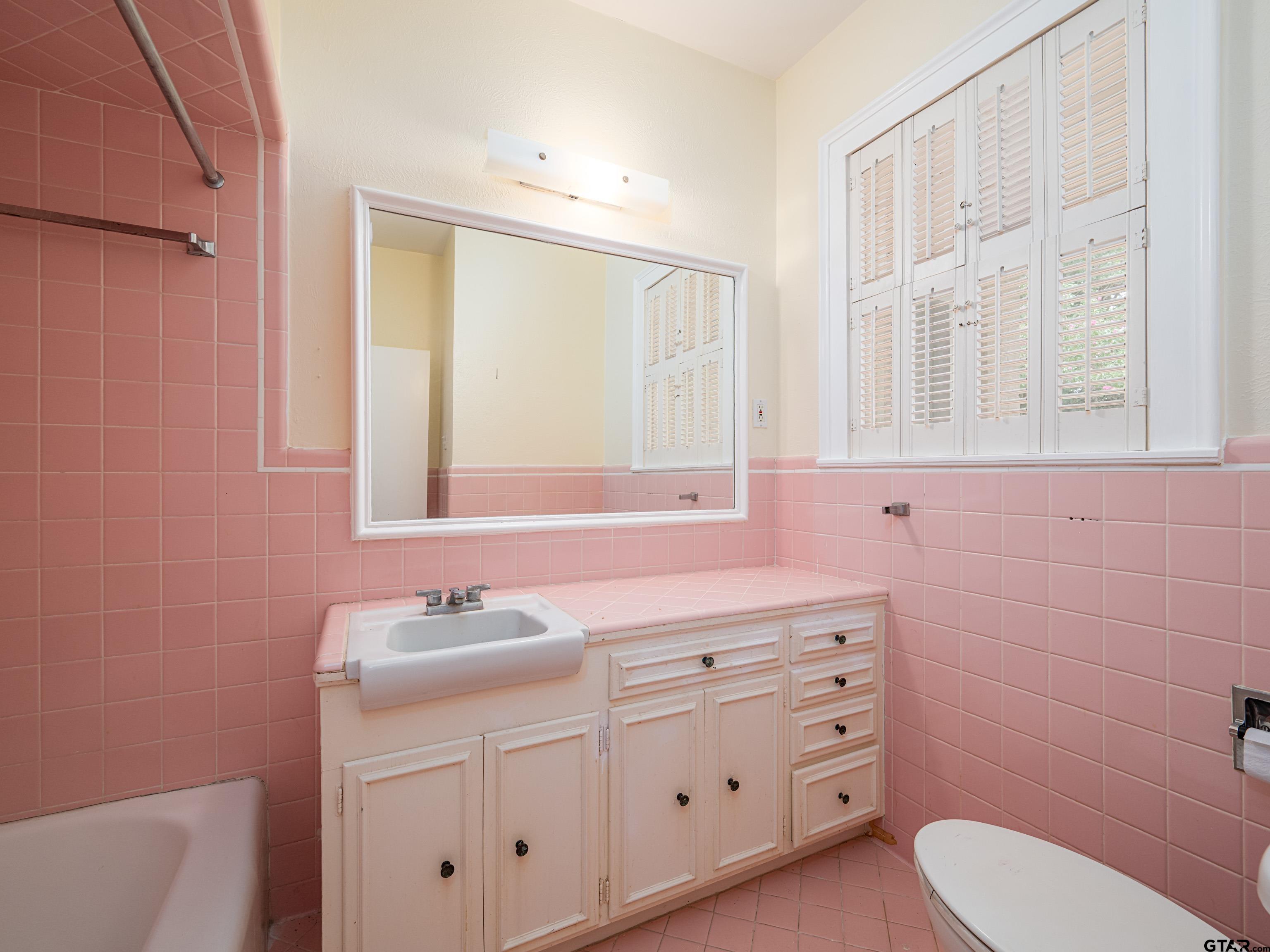 201 West Rusk Street Tyler, TX 75701 - Photo 24 of 30 a bathroom with a sink a toilet and a mirror