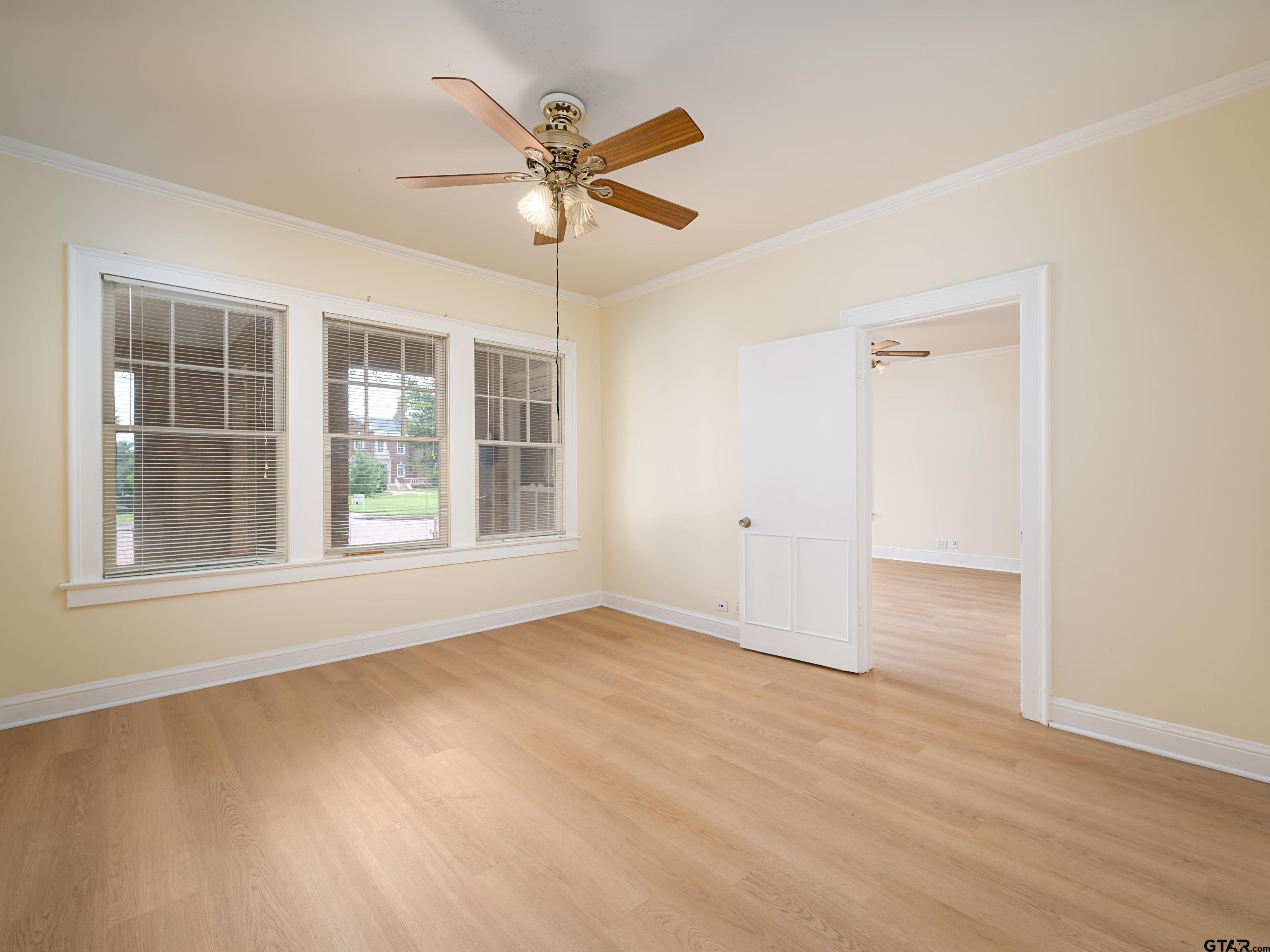 201 West Rusk Street Tyler, TX 75701 - Photo 26 of 30 an empty room with wooden floor fan and windows