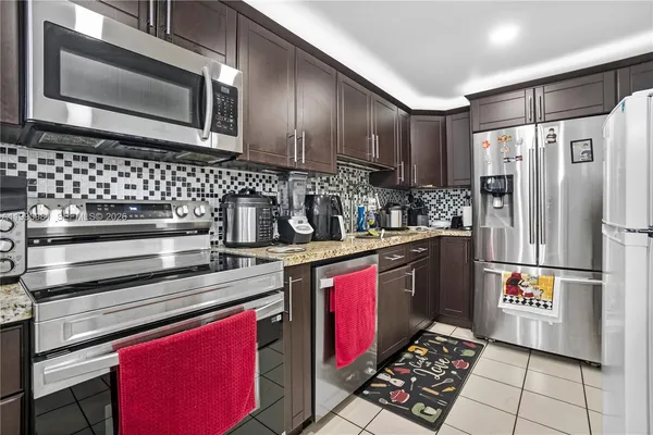 a kitchen with stainless steel appliances a sink stove and refrigerator