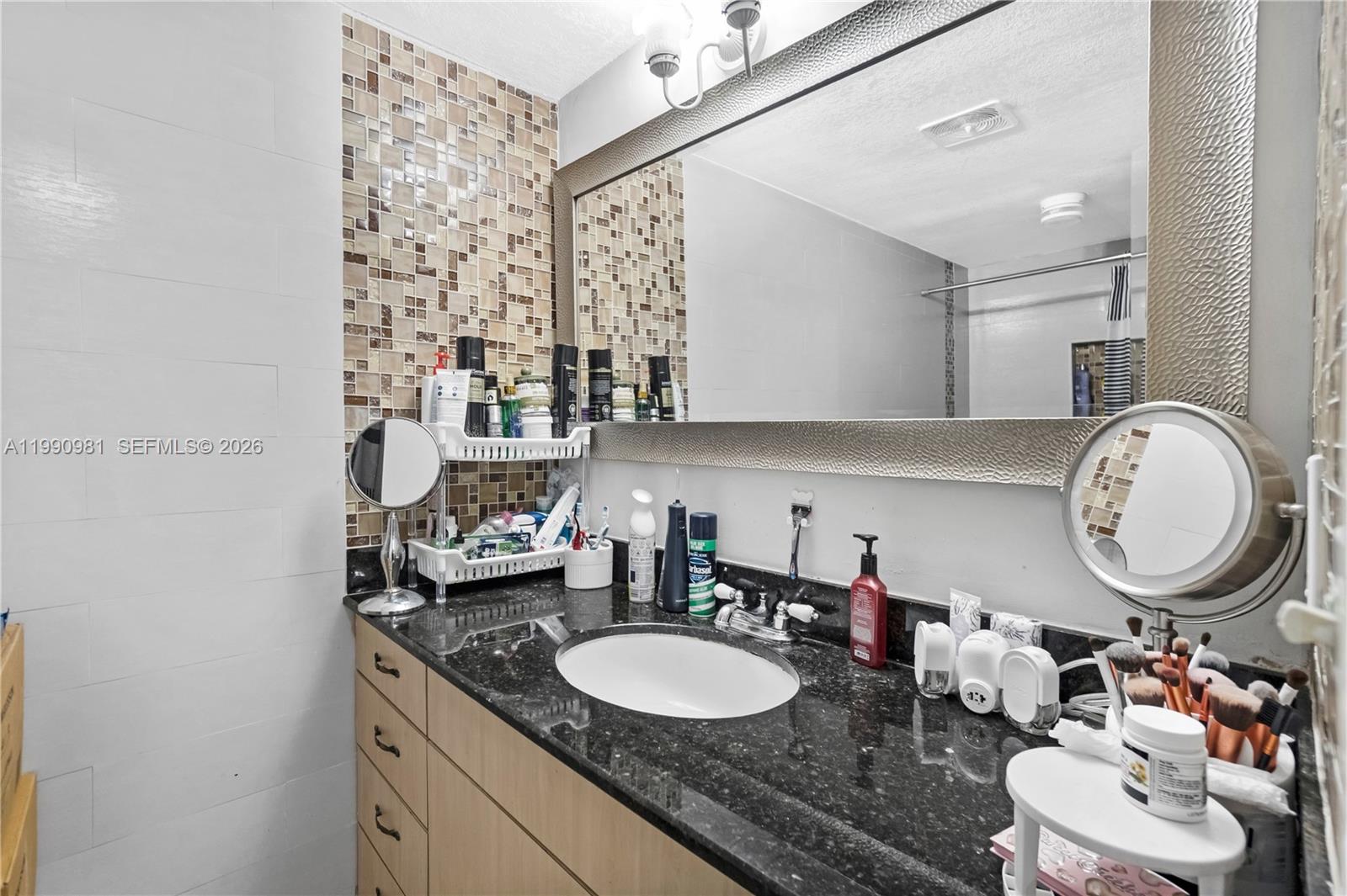 9403 Southwest 76th Street, Unit Y17 Miami, FL 33173 - Photo 21 of 30 a bathroom with a granite countertop double vanity sink and a mirror