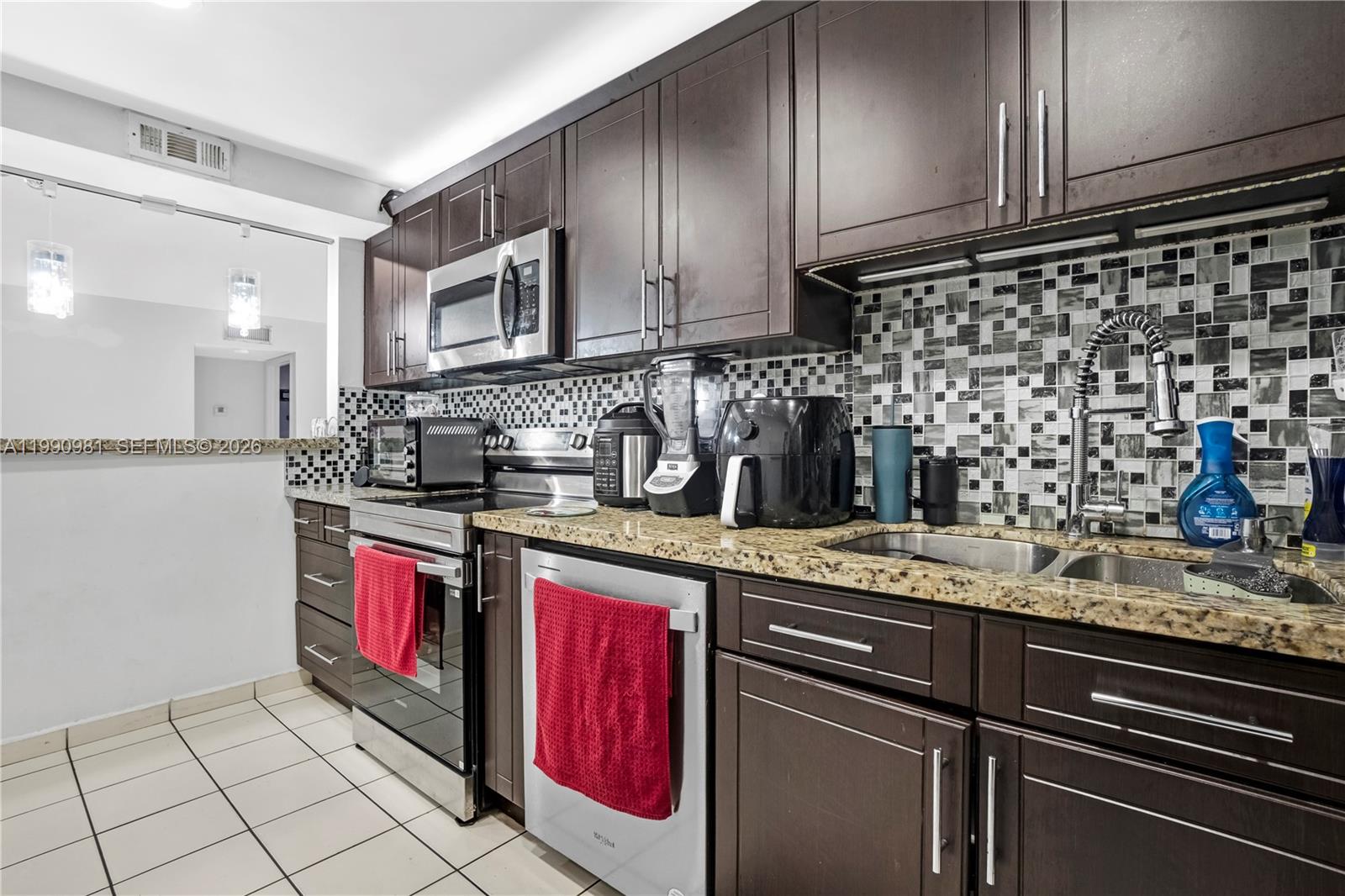 9403 Southwest 76th Street, Unit Y17 Miami, FL 33173 - Photo 3 of 30 a kitchen with stainless steel appliances granite countertop a sink stove and cabinets