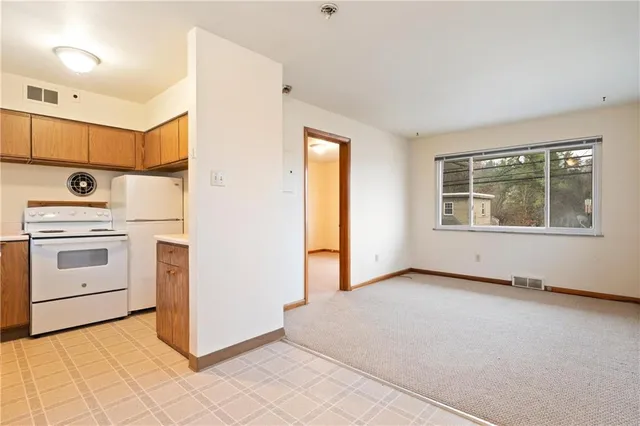 a view of an empty room with a stove and a window