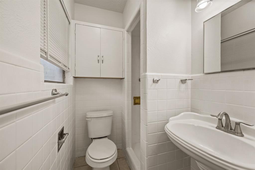 6644 Fisher Road Dallas, TX 75214 - Photo 13 of 21 a bathroom with a sink a toilet and a mirror