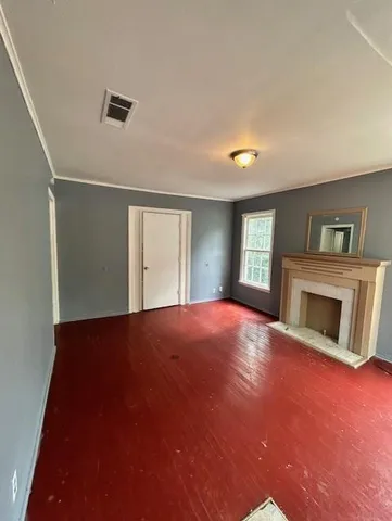 a view of empty room with wooden floor and fireplace
