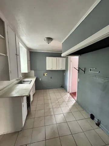 a kitchen with a sink a refrigerator and cabinets