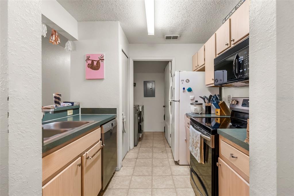 3705 Southwest 27th Street, Unit 615 Gainesville, FL 32608 - Photo 12 of 27 a kitchen with stainless steel appliances granite countertop a sink stove and refrigerator