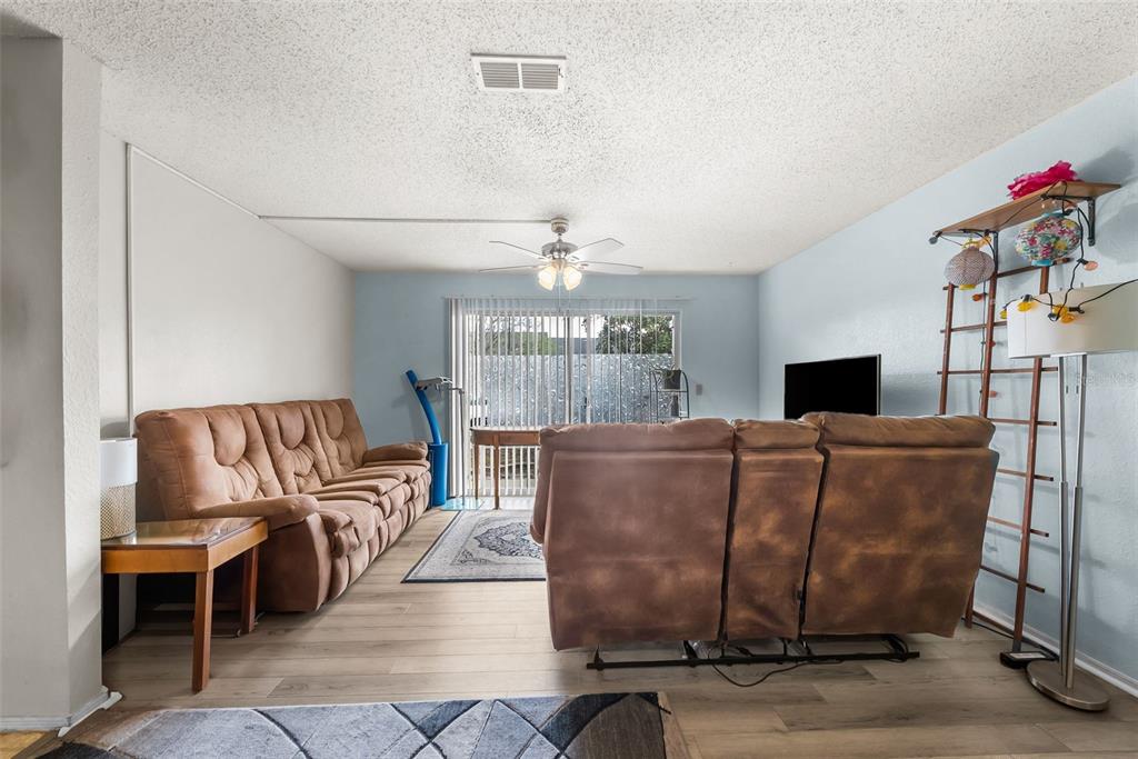 3705 Southwest 27th Street, Unit 615 Gainesville, FL 32608 - Photo 5 of 27 a living room with furniture a chandelier and a fireplace