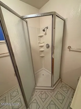 a bathroom with a glass shower door and a sink