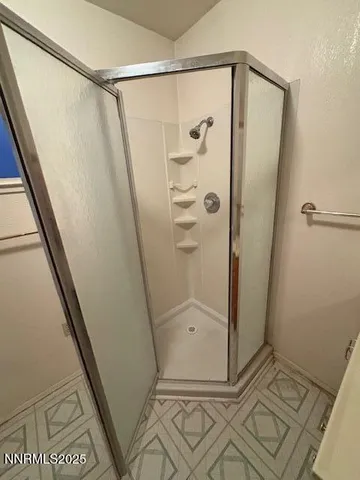 a bathroom with a glass shower door and a sink
