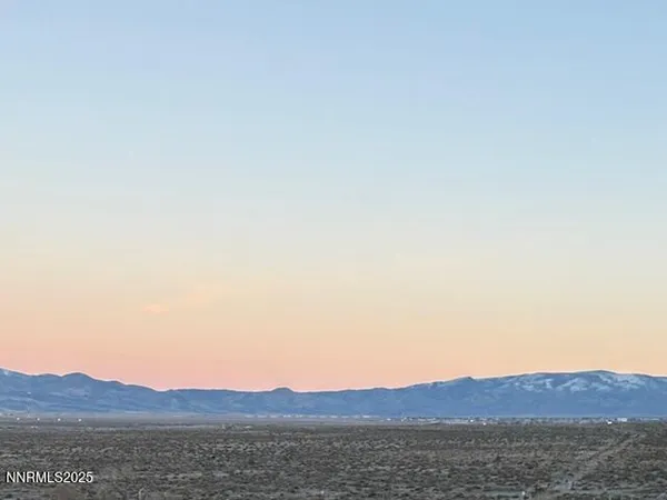 a view of mountain with sunset in background