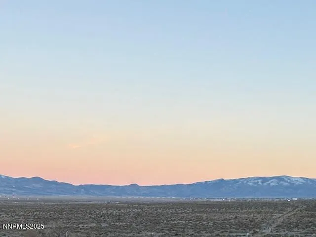 a view of mountain with sunset in background