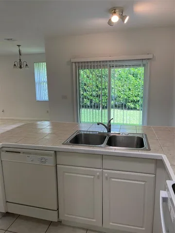 a view of a kitchen with a sink and dishwasher next to a window