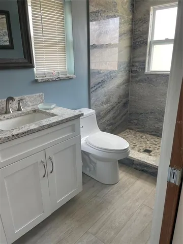 a bathroom with a granite countertop sink a mirror and a window