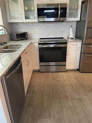 a kitchen with stainless steel appliances granite countertop a stove a sink and a microwave