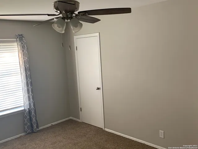 a view of a small space with a fan and a window