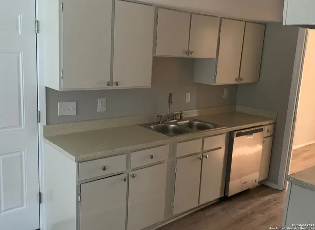a kitchen with stainless steel appliances granite countertop a sink a stove and white cabinets