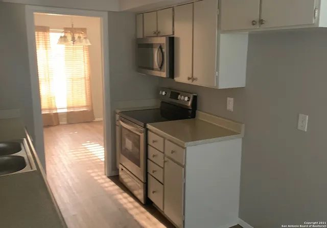 a kitchen with stainless steel appliances a stove a microwave and a sink