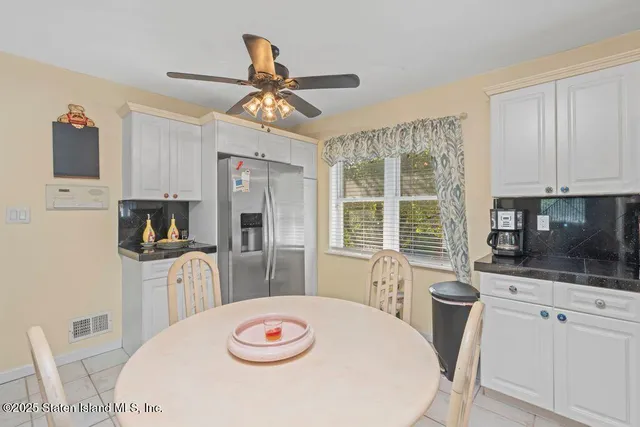a kitchen with stainless steel appliances a table chairs and a refrigerator
