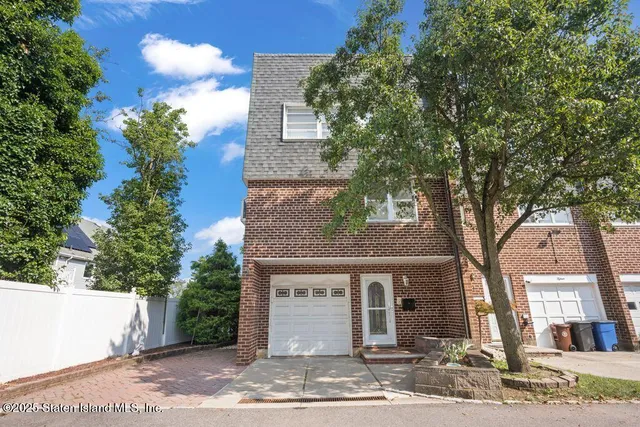 a front view of a house with a tree