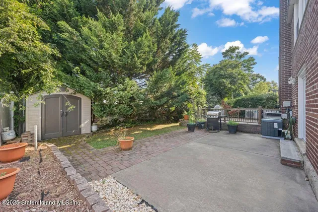 a backyard of a house with barbeque oven table and chairs