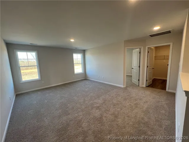 an empty room with windows and closet