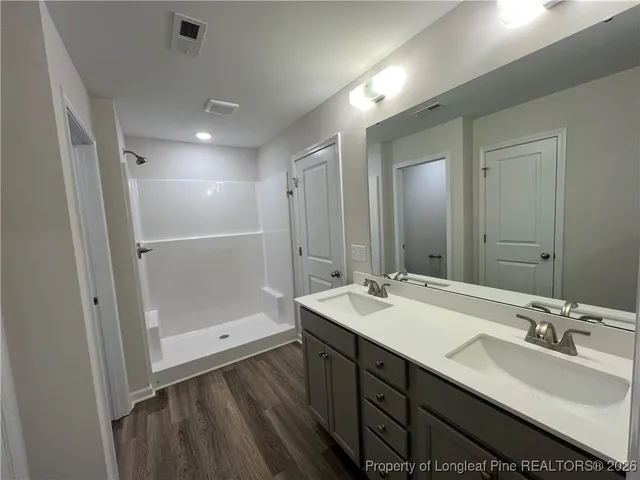 a bathroom with a double vanity sink mirror and shower