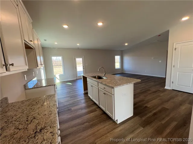 a large kitchen with stainless steel appliances granite countertop a large counter top and a wooden floors