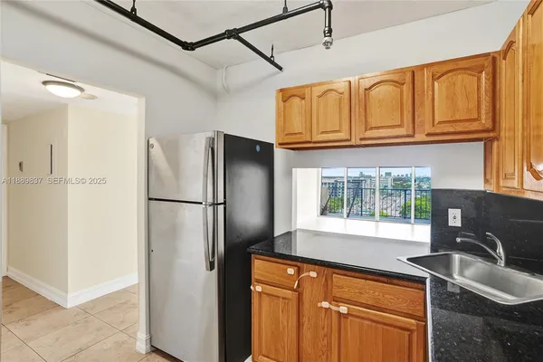a kitchen with granite countertop a sink stainless steel appliances and cabinets