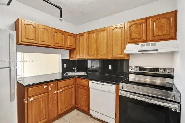 a kitchen with stainless steel appliances a stove a sink and a refrigerator