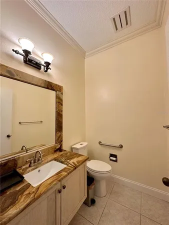 a bathroom with a granite countertop sink a toilet and mirror