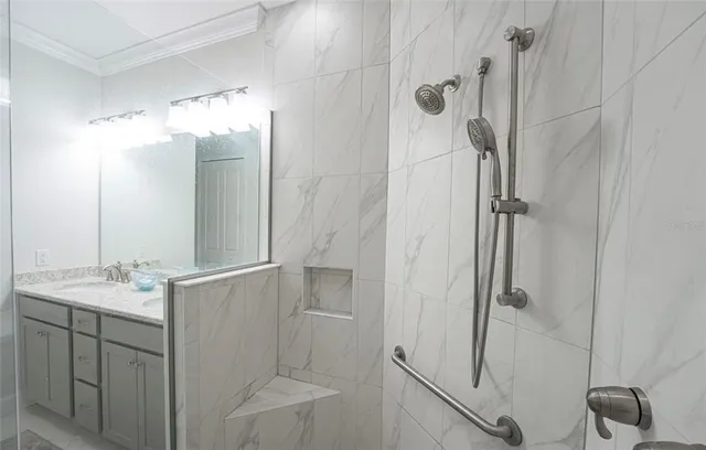 a bathroom with a granite countertop shower sink vanity and mirror