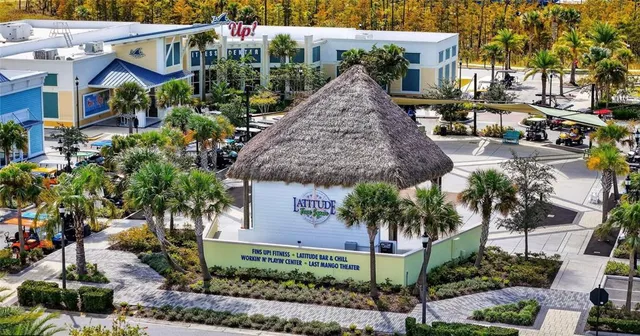 view of a pool with lawn chairs and plants
