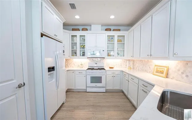 a kitchen with stainless steel appliances granite countertop a refrigerator and a sink
