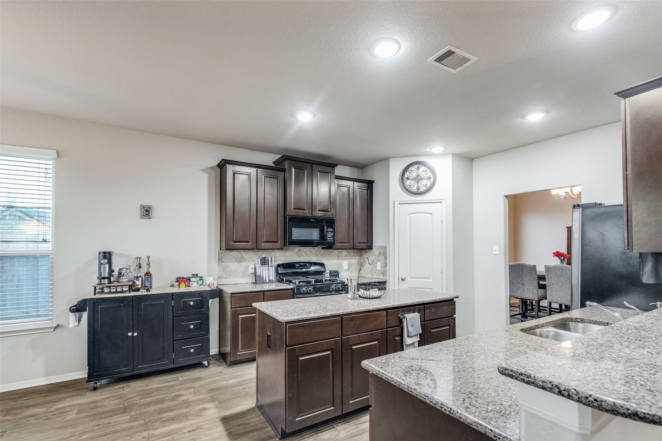 a large kitchen with kitchen island a sink stainless steel appliances and cabinets