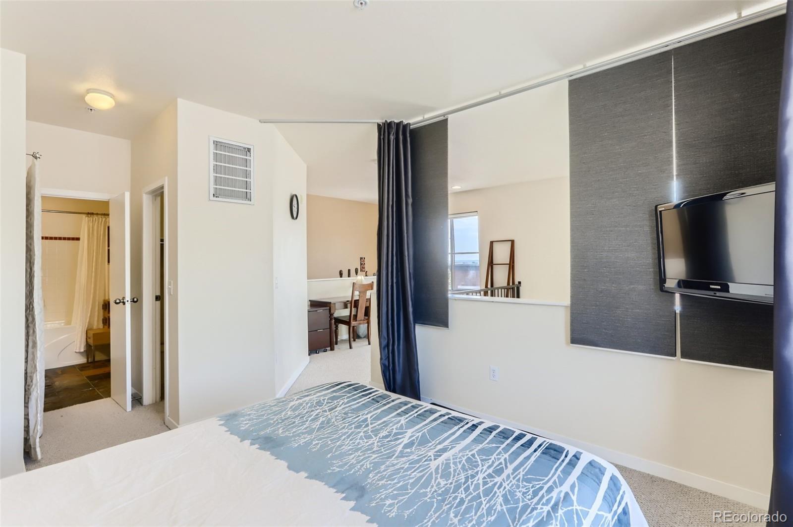 4580 Broadway, Unit 223 Boulder, CO 80304 - Photo 17 of 28 a bedroom with a bed and a flat screen tv