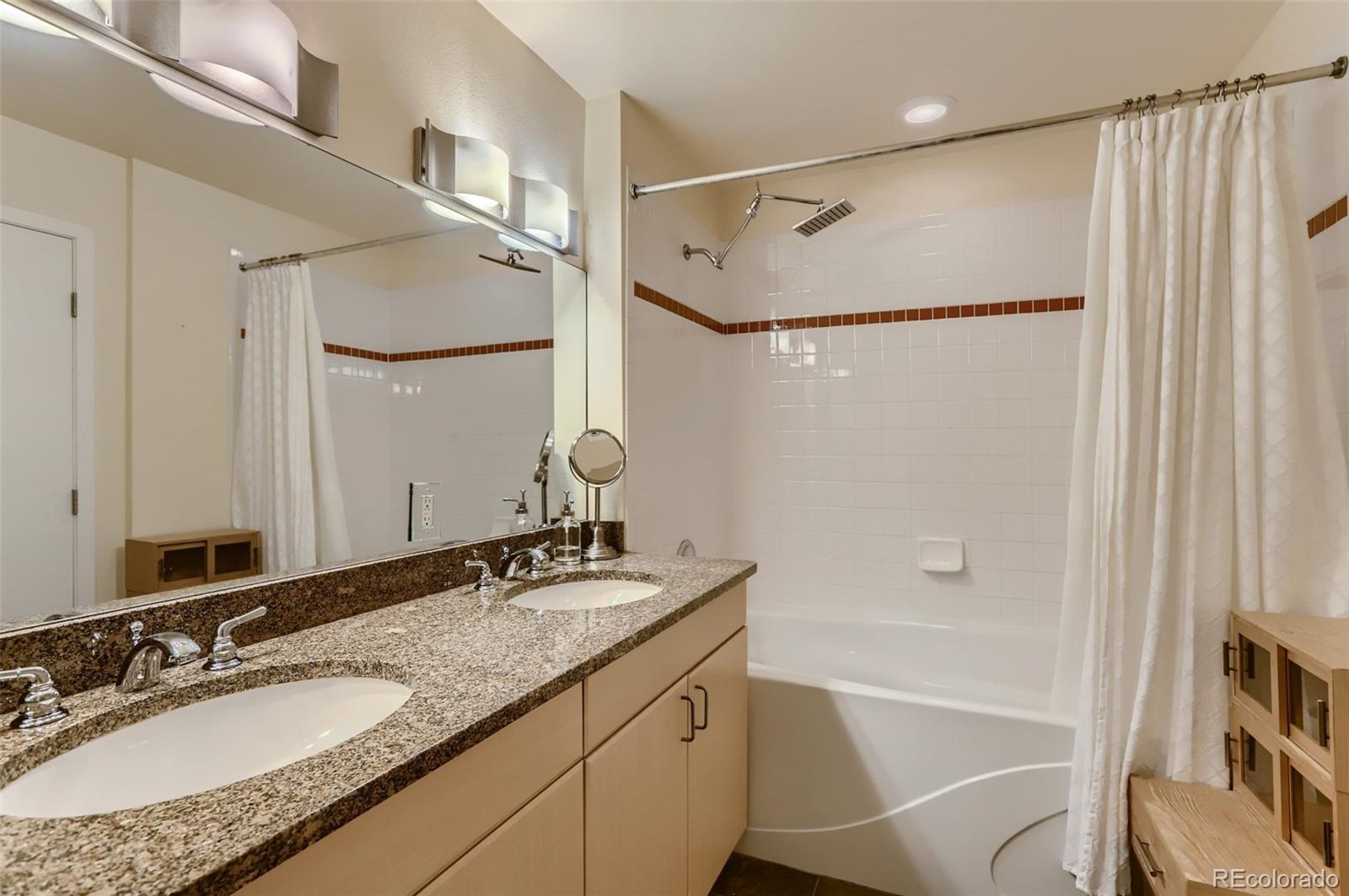 4580 Broadway, Unit 223 Boulder, CO 80304 - Photo 20 of 28 a bathroom with a granite countertop sink mirror vanity and a bathtub