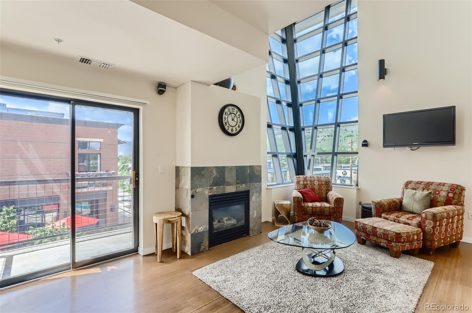 4580 Broadway, Unit 223 Boulder, CO 80304 - Photo 2 of 28 a living room with furniture a fireplace and a floor to ceiling window