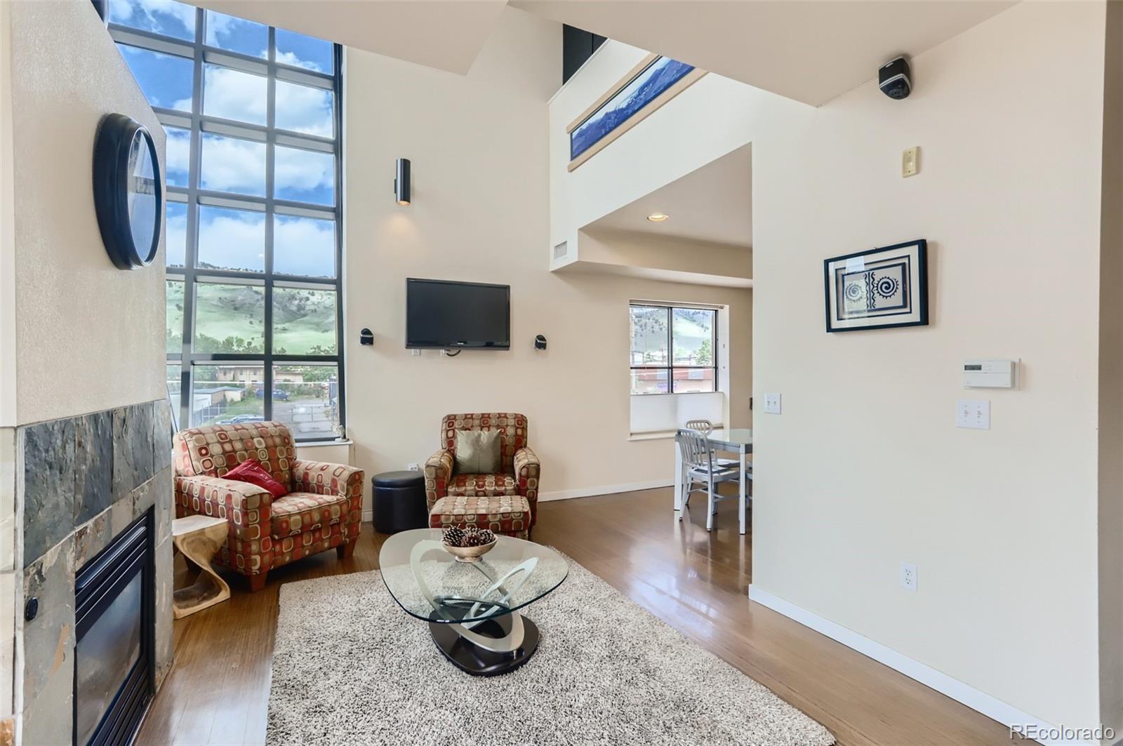 4580 Broadway, Unit 223 Boulder, CO 80304 - Photo 4 of 28 a living room with furniture a flat screen tv and a large window