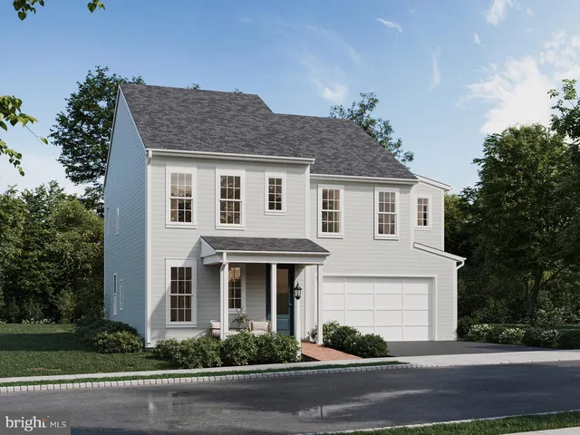 a front view of a house with plants and trees