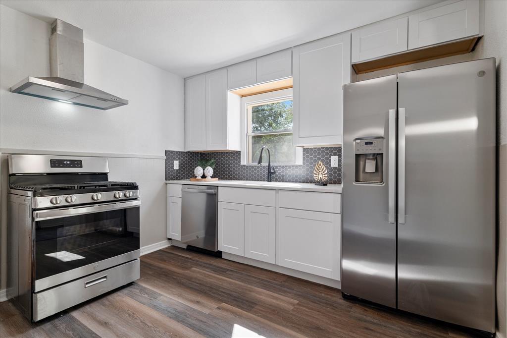 2411 Denison Street Denton, TX 76201 - Photo 8 of 15 a kitchen with a refrigerator stainless steel appliances wooden floor and window