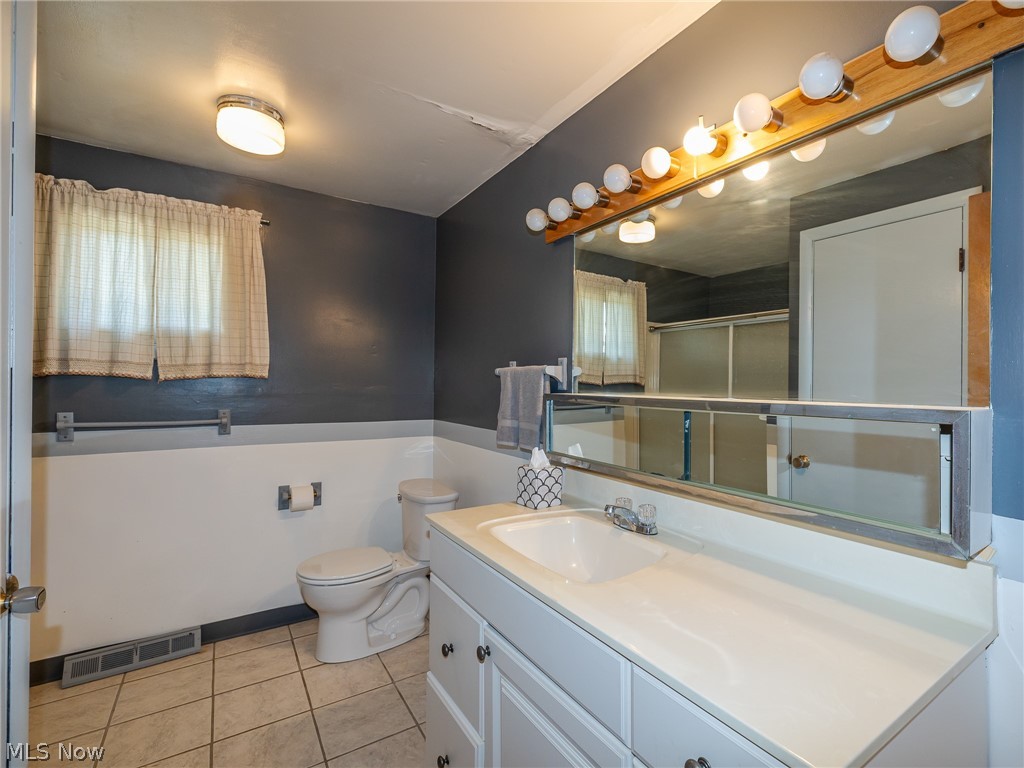 490 Mapleview Drive Seven Hills, OH 44131 - Photo 24 of 50 Full bath with vanity, light tile patterned floors, and wainscoting