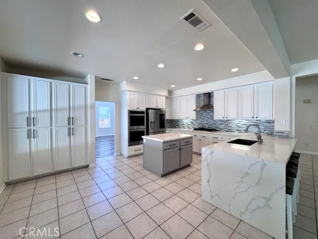a kitchen with a dining table chairs and refrigerator
