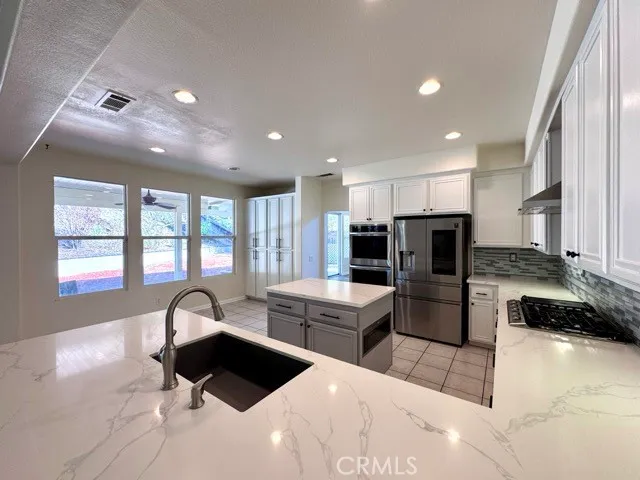 a kitchen with stainless steel appliances kitchen island granite countertop a refrigerator and a stove