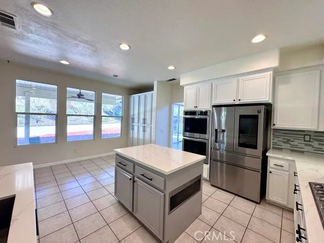 a large white kitchen with sink and cabinets