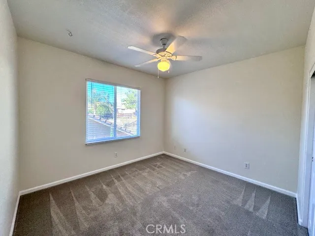 an empty room with a window and a fan
