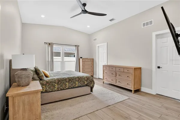 a bedroom with a bed and wooden floor